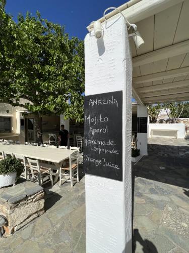 a sign in front of a restaurant with a table at Hotel Anezina in Drios
