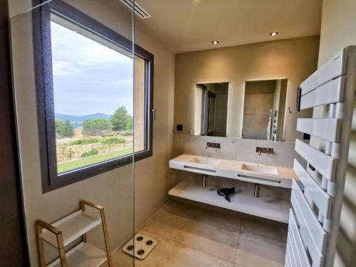 ein Badezimmer mit zwei Waschbecken und einem großen Fenster in der Unterkunft Villa La Voile au Vent - Sur les collines de la Cadière d'Azur - Villa spacieuse, 4 chambres, climatisée avec piscine à débordement, Vue mer et collines in Laouque