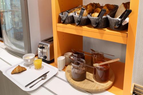 a shelf with bread and a plate of food on a counter at Premiere Classe La Ville Du Bois in La Ville-du-Bois