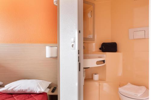 a small bathroom with a toilet and a sink at Premiere Classe La Ville Du Bois in La Ville-du-Bois