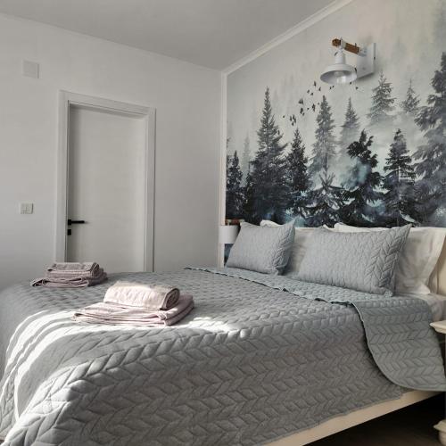 a bedroom with a large bed with a painting on the wall at My room accommodation in Curtea de Argeş