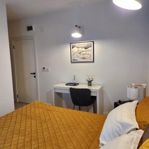a bedroom with a bed and a desk with a chair at My room accommodation in Curtea de Argeş