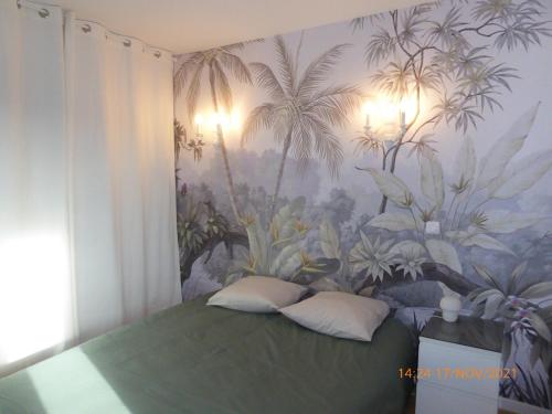 Schlafzimmer mit einem Bett und einem Wandbild von Palmen in der Unterkunft La faustinière 