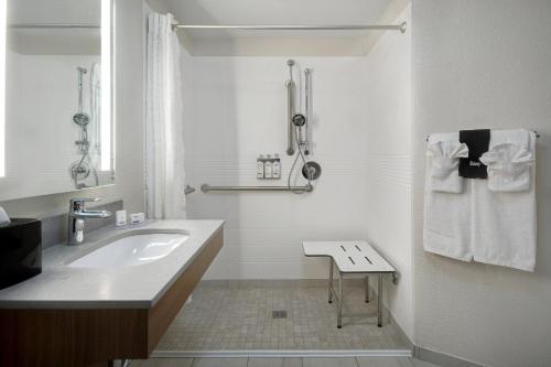 Un baño blanco con lavabo y toallero. en Candlewood Suites Columbia-Fort Jackson, an IHG Hotel en Columbia