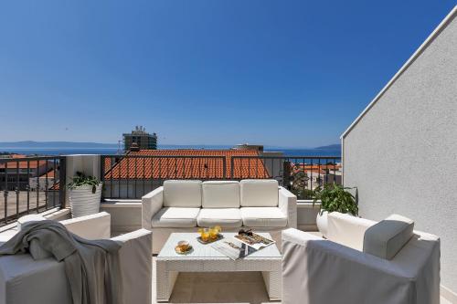 a balcony with two couches and a table on a roof at Apartment Vranješ in Makarska
