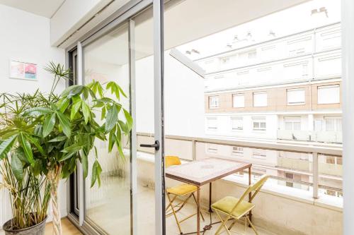 um apartamento com uma varanda com uma mesa e cadeiras em Bright apartment with double terrace em Paris