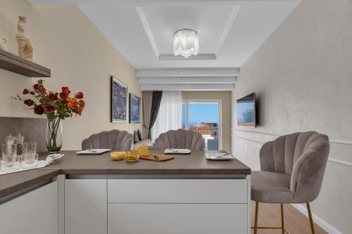 a kitchen with a island with chairs and a table at Apartment Vranješ in Makarska