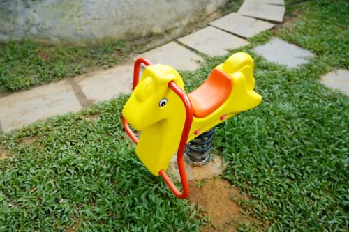 a small yellow toy elephant sitting on the grass at Kuruva Island Resort And Spa - By KABINI BREEZE in Mananthavady