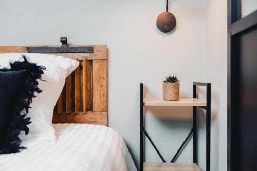 a bedroom with a bed with a wooden headboard at AU COIN DE PARADIS - Suite samérienne in Samer