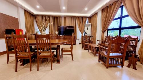 a dining room with a wooden table and chairs at Residencia Orlina in Dumaguete