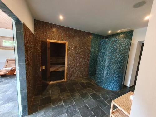 a room with a shower with a tiled wall at Ski park Gruň in Staré Hamry