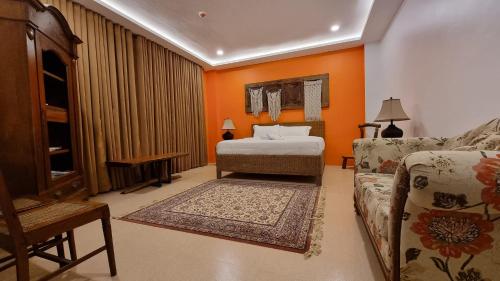 a living room with a bed and a couch at Residencia Orlina in Dumaguete