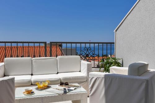 a balcony with white furniture and a view of the ocean at Apartment Vranješ in Makarska