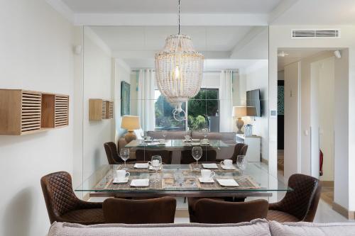 a living room with a glass table and chairs at Apartament Belharucas, 400 meters from beach in Albufeira