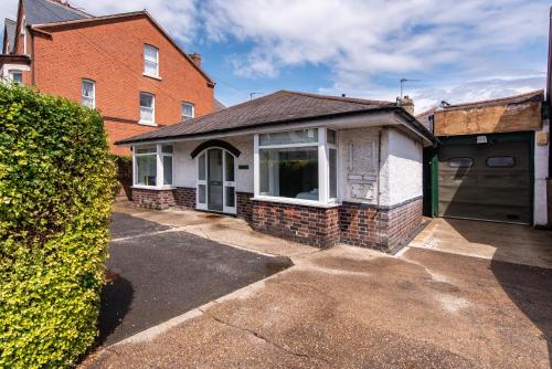 a white house with a window and a driveway at Gertrude House - Spacious 3BR Bungalow in Nottingham in Nottingham