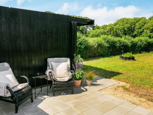 two chairs and a table next to a black fence at 4 person holiday home in Rudkøbing-By Traum in Rudkøbing