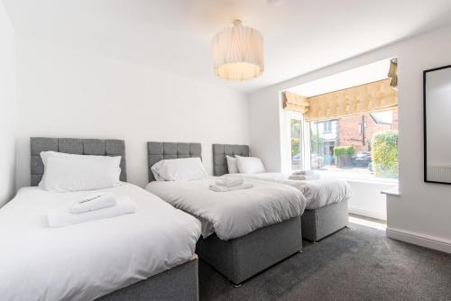 1 Schlafzimmer mit 2 Betten und einem Fenster in der Unterkunft Gertrude House - Spacious 3BR Bungalow in Nottingham in Nottingham