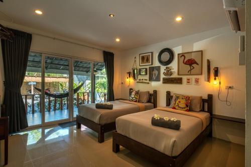 a bedroom with two beds and a balcony at All At Sea Beach Resort in Baan Tai