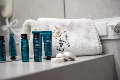 a bathroom counter with two bottles of shampoo and a towel at Nowe Apartamenty z antresolą z 2 sypialniami - REWAL in Rewal