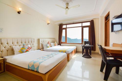 1 Schlafzimmer mit 2 Betten, einem Tisch und einem Schreibtisch in der Unterkunft OYO Home 78009 Avon Villa Kanlog in Shimla