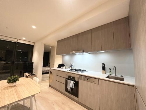 a kitchen with a sink and a stove top oven at Luxury 1 Bedroom Apartment in Adelaide CBD - 1 minute walk to Rundle mall - Free Wifi & Netflix in Adelaide