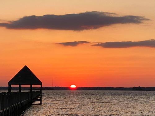 a pier with a gazebo on the water at sunset at Holiday Inn Express & Suites - Ocean City by IHG in Ocean City