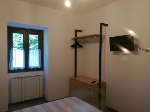 ein Schlafzimmer mit einem Bett, einer Kommode und einem Fenster in der Unterkunft Sweet Home Casa Vacanze il b&b in Songavazzo