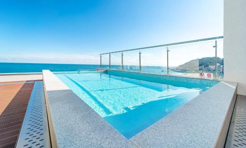 a swimming pool with a view of the ocean at Paul Mare Pool Villa in Busan