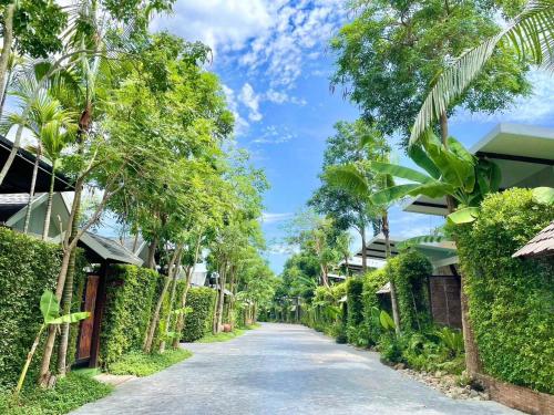 a street in a resort with trees and bushes at IP Plus Pool Villa Pattaya in Jomtien Beach