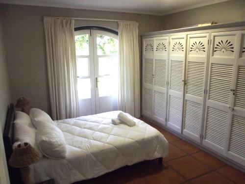 a bedroom with a white bed and a window at Caribbean Estates Montego Bay 05 in Port Edward