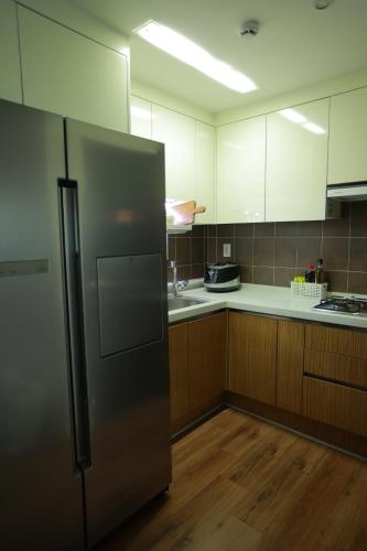 een keuken met een roestvrijstalen koelkast en houten kasten bij Sunyhouse Female Only Foreign Only in Seoul