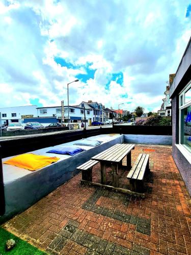 a wooden bench sitting on top of a brick patio at Elemental Surf Lodge in Newquay