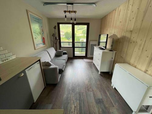 ein Wohnzimmer mit einem Sofa und einem Tisch in der Unterkunft Studio refait à neuf avec balcon - Famille - Parking couvert in Chamrousse