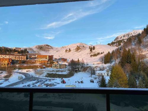 a view from a window of a town in the snow at Studio refait à neuf avec balcon - Famille - Parking couvert in Chamrousse