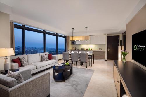 a living room and kitchen with a couch and a table at Oakwood Residence Hangzhou in Hangzhou