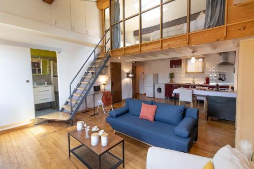un salon avec un canapé bleu et une mezzanine dans l'établissement Le Chaleureux - Un bijou de Toulouse - So Cozy, à Toulouse