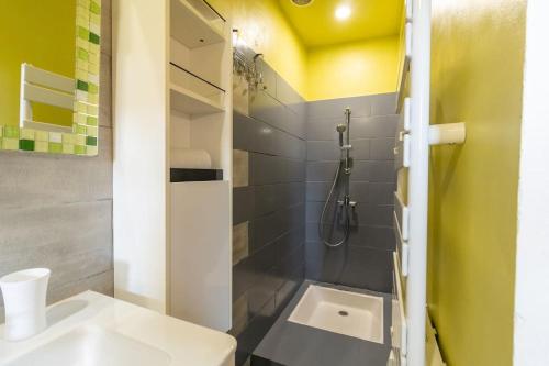 La salle de bains est pourvue d'une douche et d'un lavabo blanc. dans l'établissement Le Chaleureux - Un bijou de Toulouse - So Cozy, à Toulouse