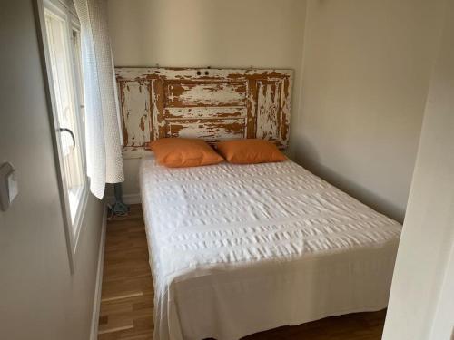 a small bed with two orange pillows in a room at Gästhus i Slöinge nära Skrea strand in Slöinge