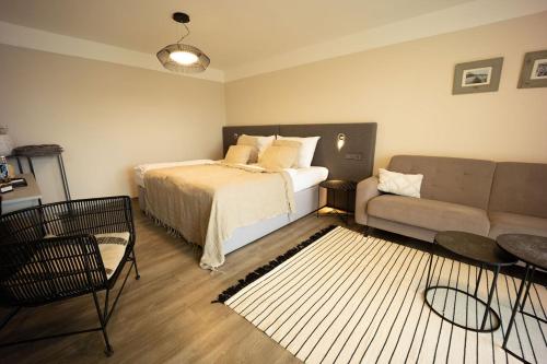 a bedroom with a bed and a couch at Wellness Hotel Volarik in Mikulov