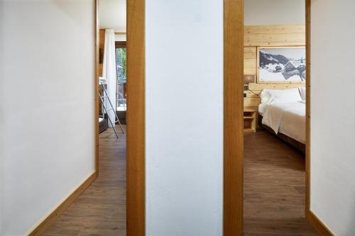 a hallway leading to a bedroom with a bed at Hotel Garni dello Sportivo in Madonna di Campiglio