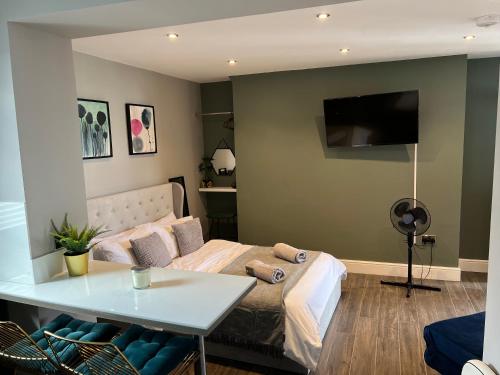 1 dormitorio con cama y mesa blanca en Peaceful & Stylish Brighton Studio Apartment, en Brighton & Hove
