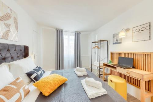 1 dormitorio con 1 cama y escritorio con ordenador portátil en Château de Versailles à 7 minutes plus parking gratuit à 4 minutes, en Le Chesnay