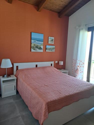 Apartment Terre Roveresche في San Giorgio di Pesaro: غرفة نوم بسرير بحائط برتقالي
