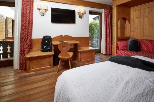 a bedroom with a bed and a desk and a table at Hotel Garni dello Sportivo in Madonna di Campiglio