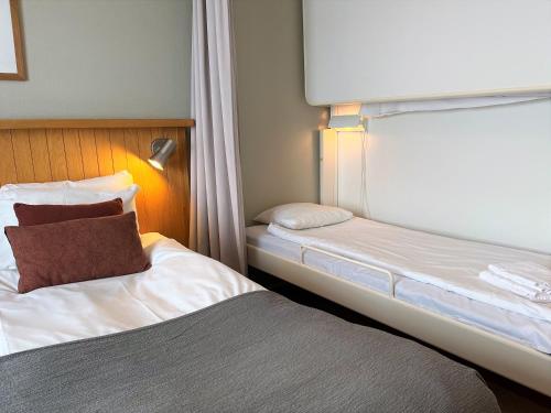 a hotel room with two beds and a window at Hotell Funäsdalen in Funäsdalen