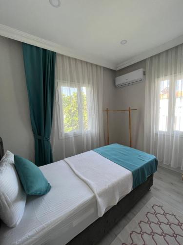 1 dormitorio con 1 cama grande y cortinas verdes en Apart Portakal Çiçeği, en Kas