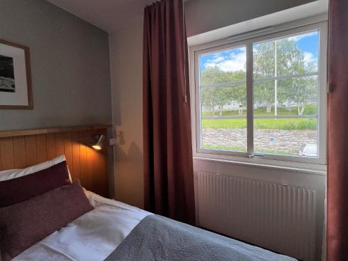 sypialnia z łóżkiem i dużym oknem w obiekcie Hotell Funäsdalen w mieście Funäsdalen