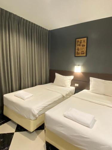 a hotel room with two beds with white sheets at The CHESS Samui in Chaweng