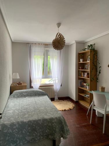 1 dormitorio con cama, mesa y ventana en Habitación privada para 2 personas a 10 min de la playa en Santander