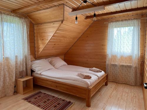 - une chambre avec un lit dans une pièce en bois dans l'établissement Cabanówka, à Hoczew